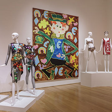 Match Made in Heaven exhibition showing large painting and mannequins displaying designs by Jeremy Scott