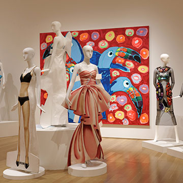 a large painting of a toucan and mannequins wearing Jeremy Scott designs