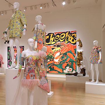 clothing designs on mannequins and a large painting of Cheetos