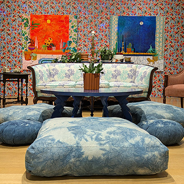 lounge with a sofa, coffee table, cushions and two works of art on the wall