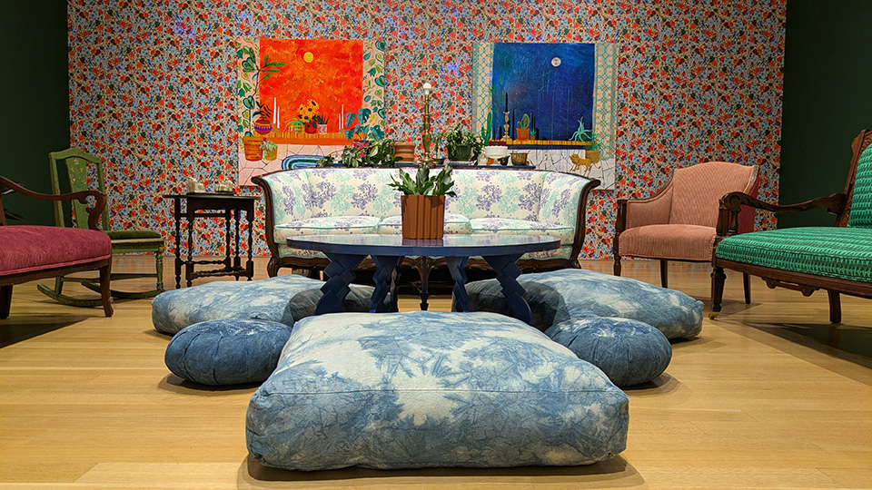 lounge with a sofa, coffee table, cushions and two works of art on the wall